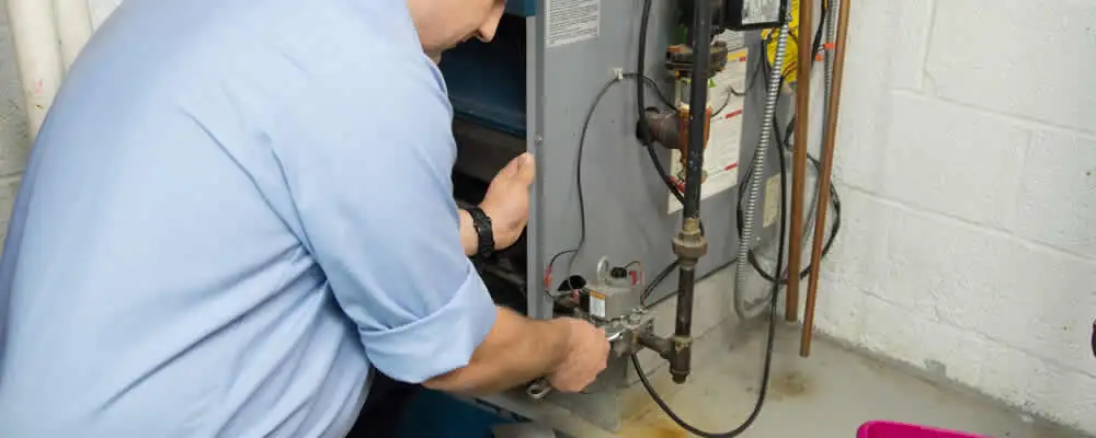 Furnace repair technician inspecting and servicing a home heating system in Chico, CA