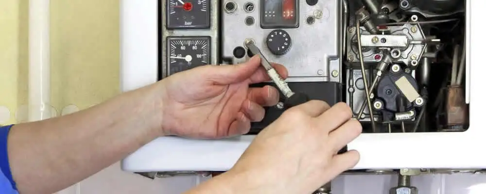 Heating repair technician adjusting boiler controls and components in Chico, CA