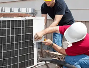 HVAC technicians repairing an outdoor AC unit on a rooftop in Chico, CA