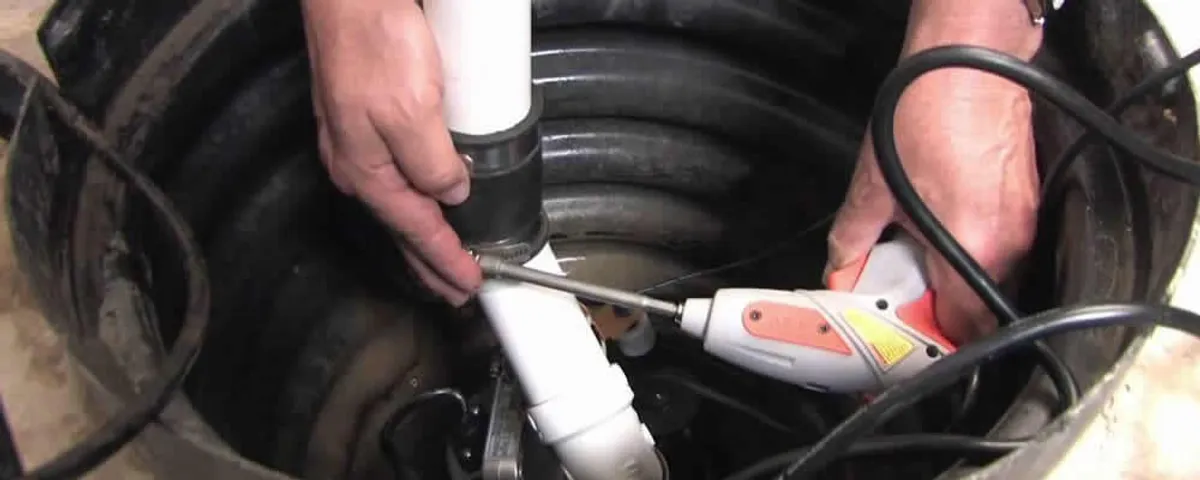 Sump pump installation technician connecting PVC discharge piping in Chico, CA