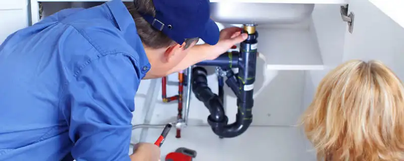 Plumber repairing under-sink drain pipes and fittings in Chico, CA